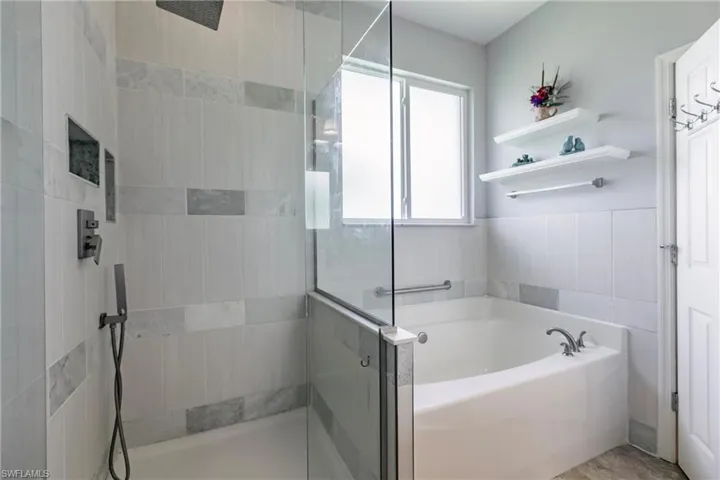 Bathroom with shower with separate bathtub and tile walls
