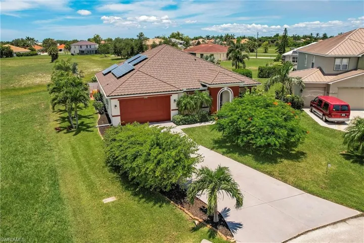 View of front of home with a garage and a front lawn