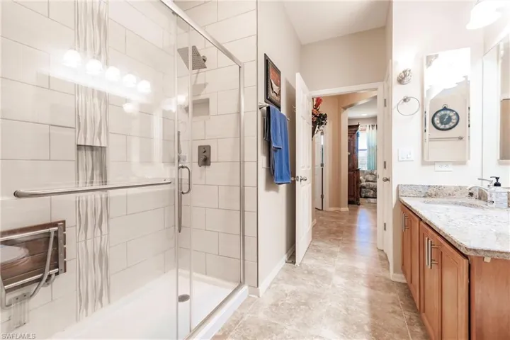 Bathroom with walk in shower, vanity, and tile floors