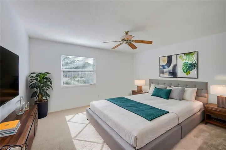 Primary Bedroom featuring neutral carpeting, a ceiling fan with light fixture, and a single-hung window