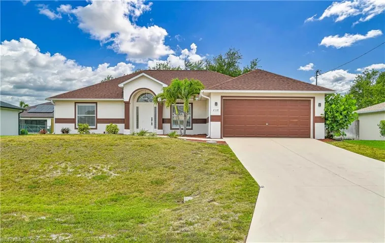 Single story home featuring a garage, a front yard, and solar panels
