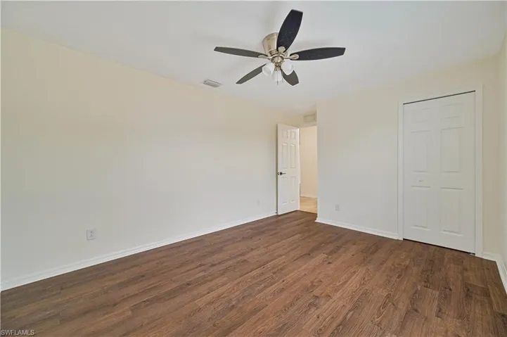 Unfurnished bedroom with dark hardwood / wood-style floors and ceiling fan