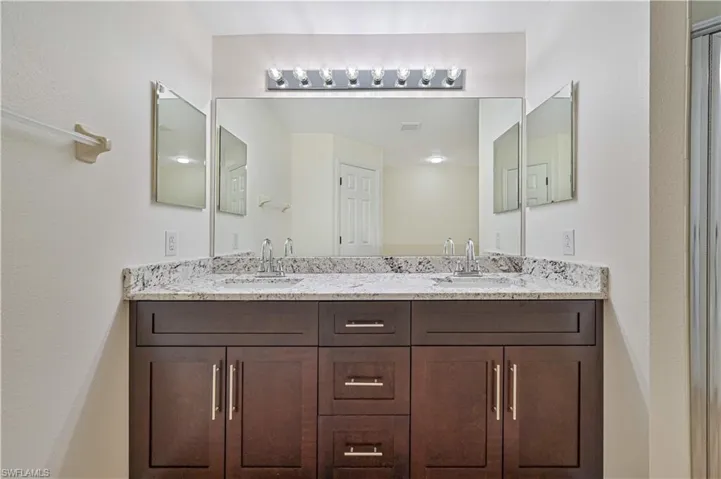 Bathroom featuring vanity with extensive cabinet space and dual sinks