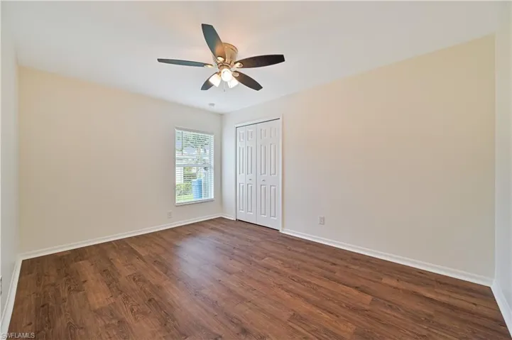Unfurnished room with ceiling fan and dark hardwood / wood-style flooring