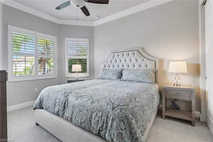 Bedroom featuring ceiling fan, light colored carpet, and crown molding
