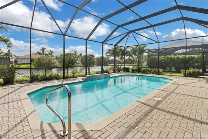 View of swimming pool featuring a lanai, a water view, and a patio area