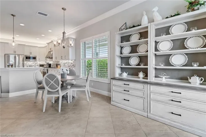 Dining space featuring crown molding, light tile patterned floors, and a chandelier