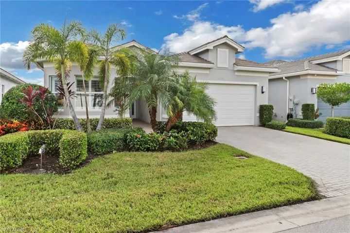 View of front of property featuring a garage and a front lawn