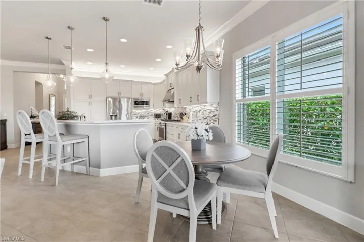 Dining area featuring crown molding, a notable chandelier, and light tile patterned floors
