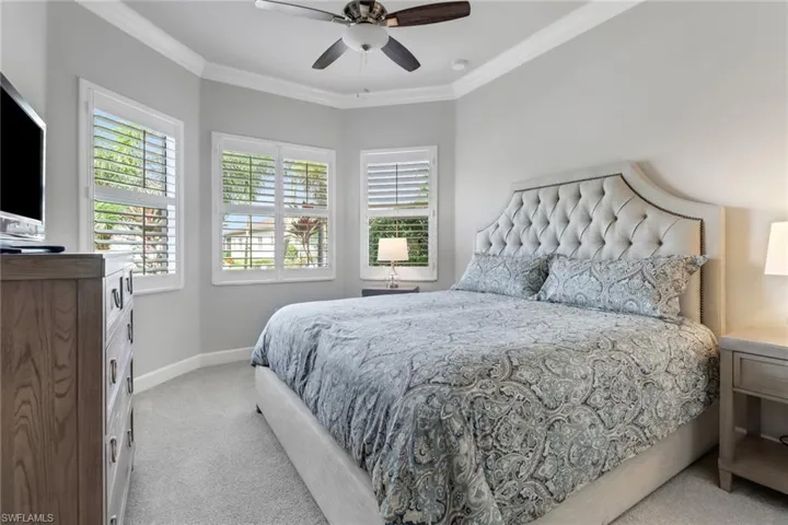 Bedroom featuring light carpet, crown molding, and ceiling fan