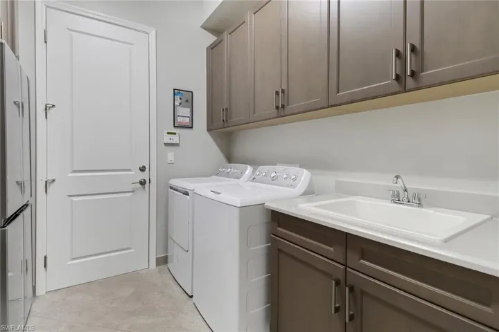 Laundry area featuring cabinets, washing machine and clothes dryer, and sink