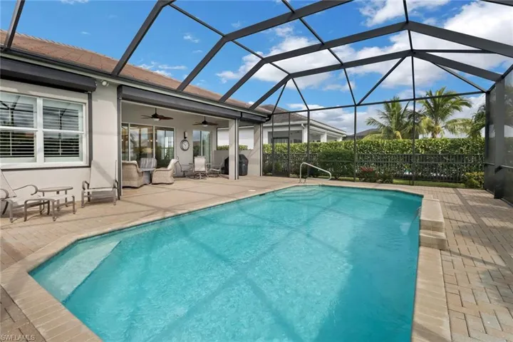 View of pool featuring a lanai, ceiling fan, and a patio area