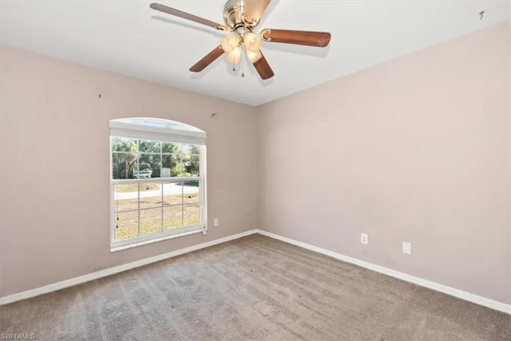 Unfurnished room featuring light carpet and ceiling fan