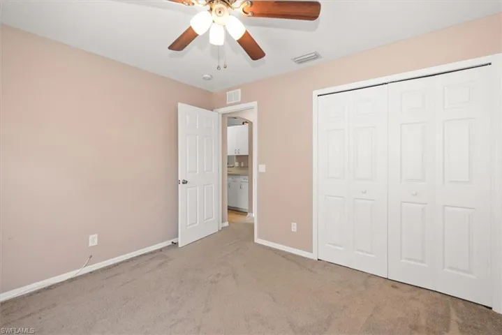 Unfurnished bedroom featuring carpet floors, a closet, and ceiling fan