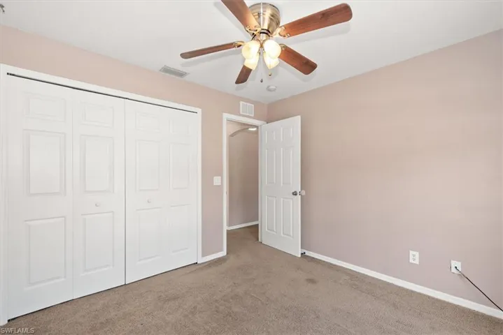 Unfurnished bedroom with carpet, a closet, and ceiling fan