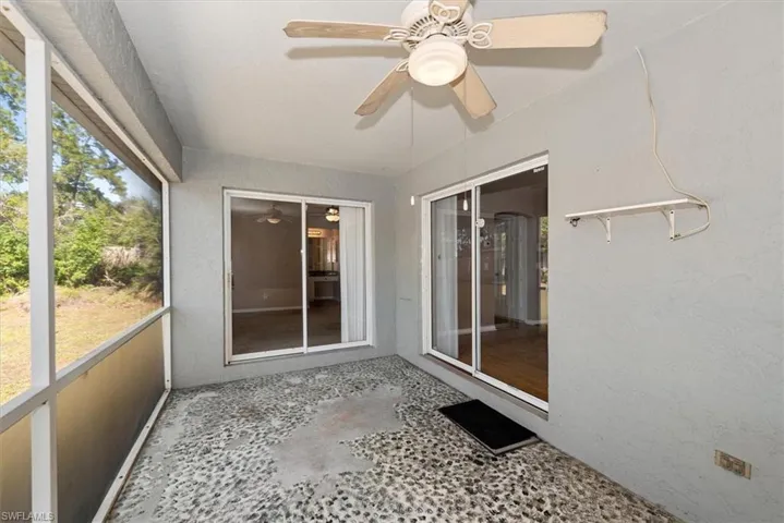 Unfurnished sunroom featuring a ceiling fan