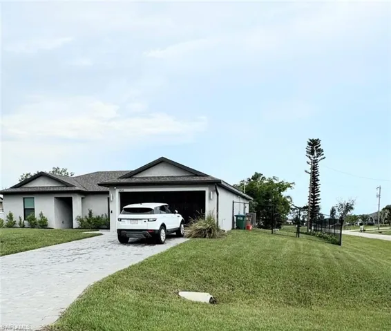 View of home's exterior with a lawn, decorative driveway, stucco siding, and an attached garage