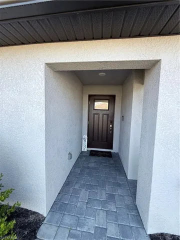 Entrance to property with stucco siding