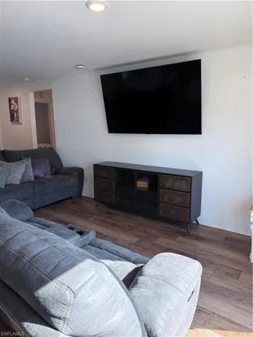 Living area with hardwood / wood-style floors and recessed lighting