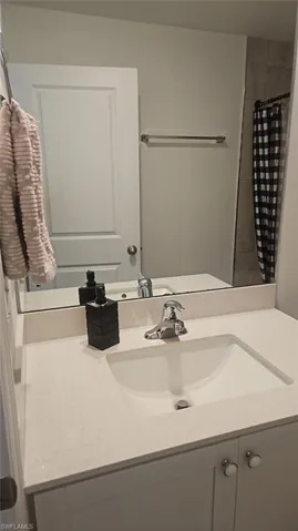 Vanity featuring a white countertop with an integrated sink and chrome faucet