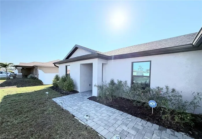 Entrance to property featuring a yard and stucco siding