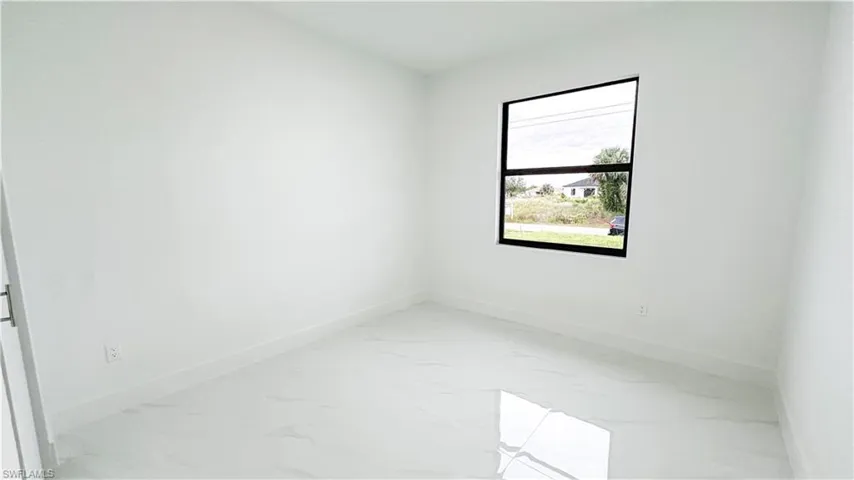 Crisp white walls, large window with black trim, and polished tile flooring