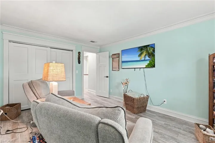 Wood-finish flooring with white trim and crown molding