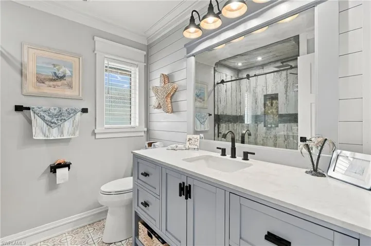 Double vanity with light countertops, black fixtures, and integrated sink