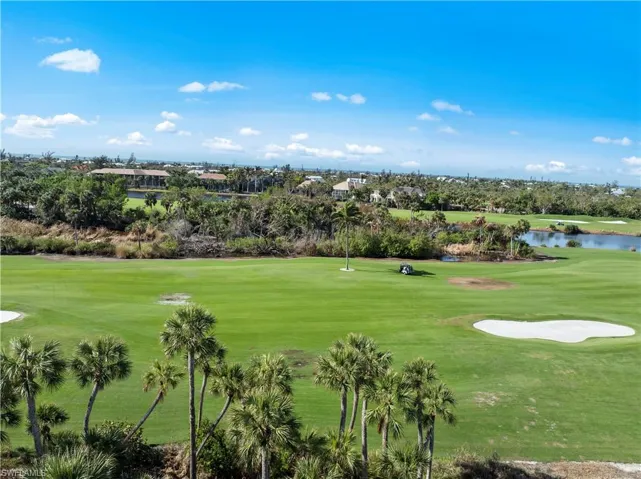 View of home's community featuring view of golf course, a water view, and a lawn