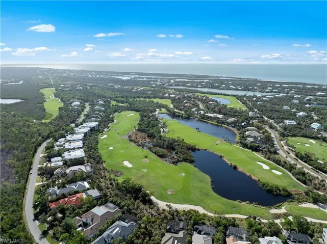 Aerial perspective of suburban area with a golf course and a nearby body of water