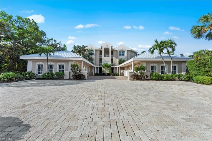 View of front of house with stucco siding, decorative driveway, and metal roof