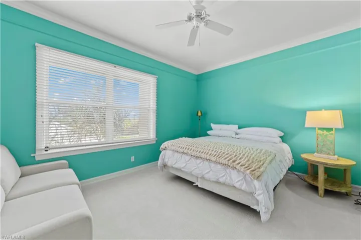 Bedroom with baseboards, crown molding, carpet, and a ceiling fan