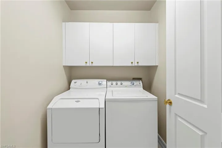 Washroom featuring cabinet space and separate washer and dryer