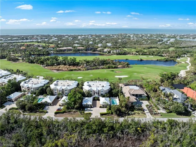 Aerial view of residential area with a golf club and a large body of water