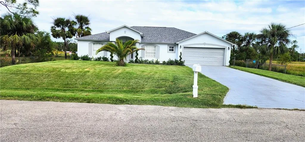 Single story home with a front yard and a garage
