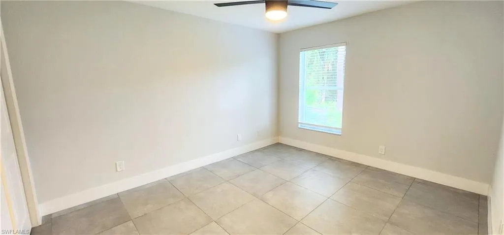 Unfurnished room with ceiling fan and light tile patterned floors