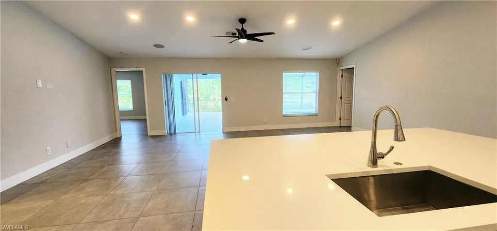 Kitchen featuring ceiling fan, sink, and light tile patterned floors