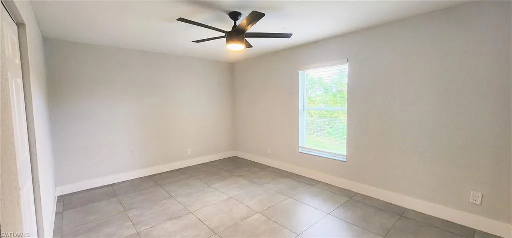 Tiled spare room with ceiling fan