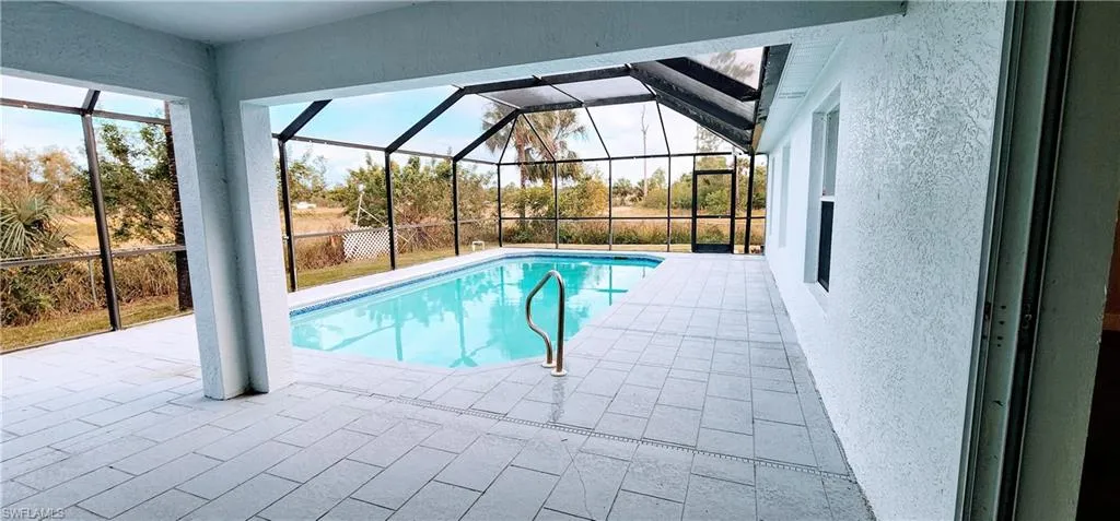 View of pool with a patio area and a lanai