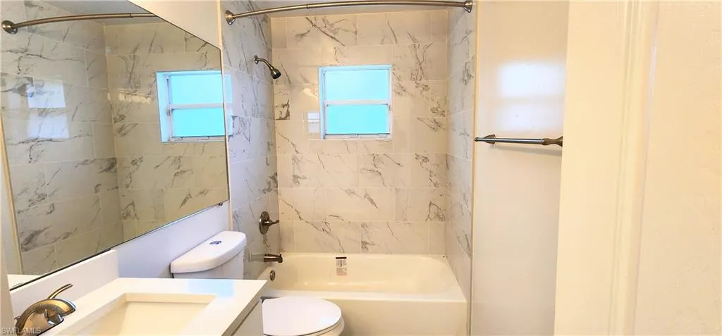 Full bathroom with vanity, toilet, and tiled shower / bath