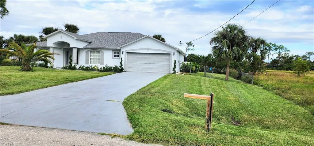 Single story home with a front lawn and a garage