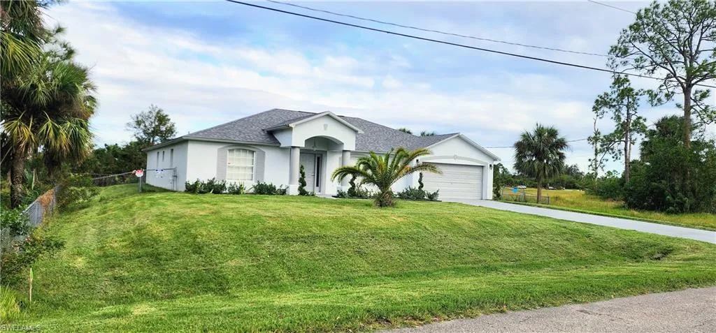 View of front of property with a front lawn and a garage