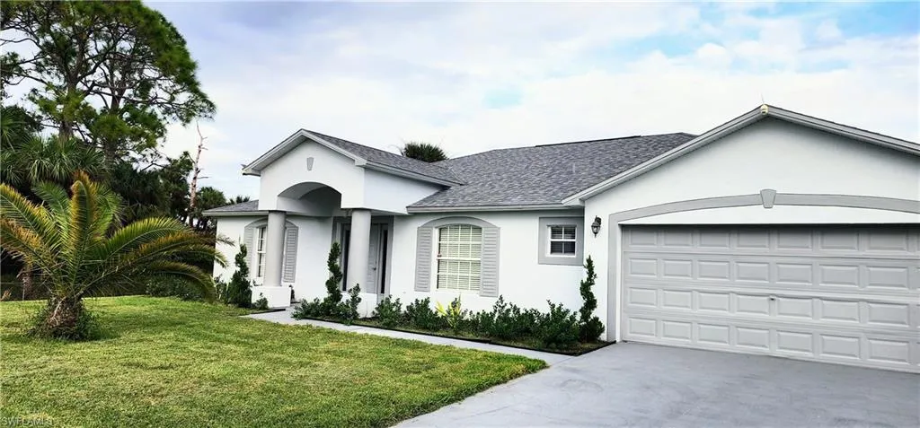 Ranch-style home with a front yard and a garage