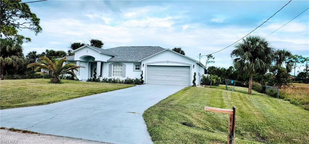 Single story home with a front yard and a garage