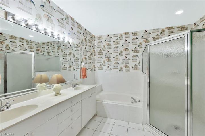 En suite bathroom with a soaking tub, separate tile shower, and dual sinks/vanity areas.