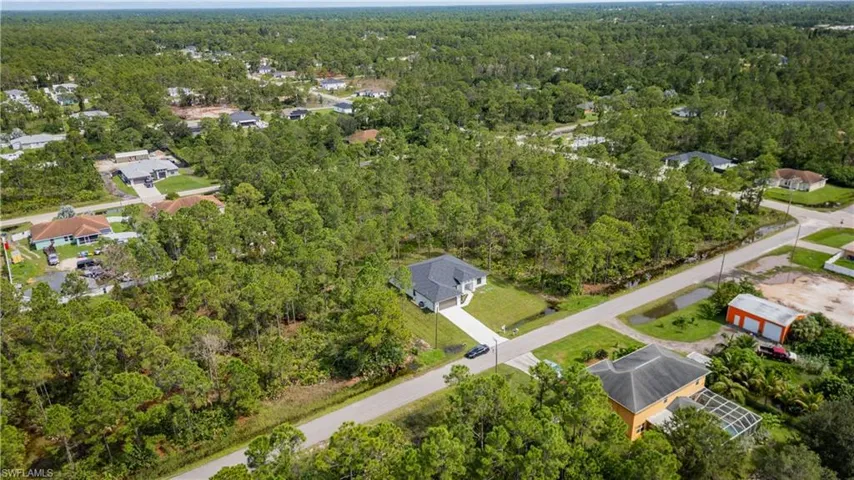 View of property location with a heavily wooded area