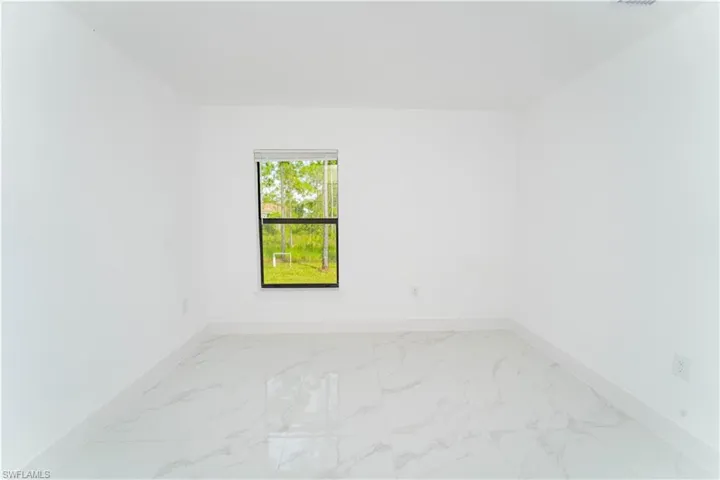Empty room featuring light marble finish floors