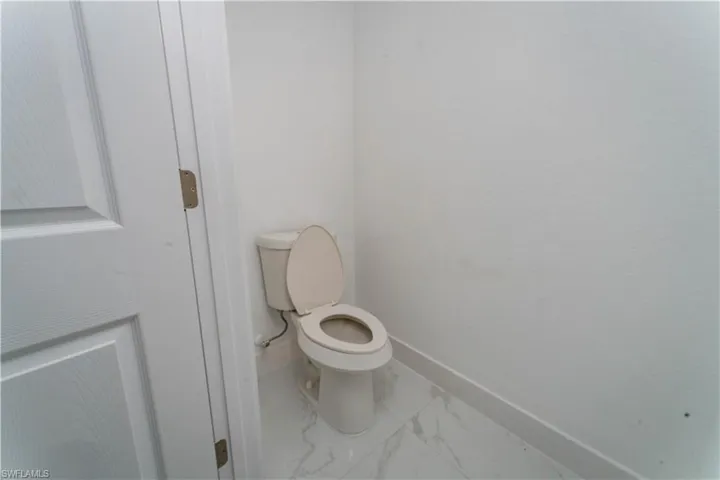 Bathroom featuring baseboards and marble look tile flooring