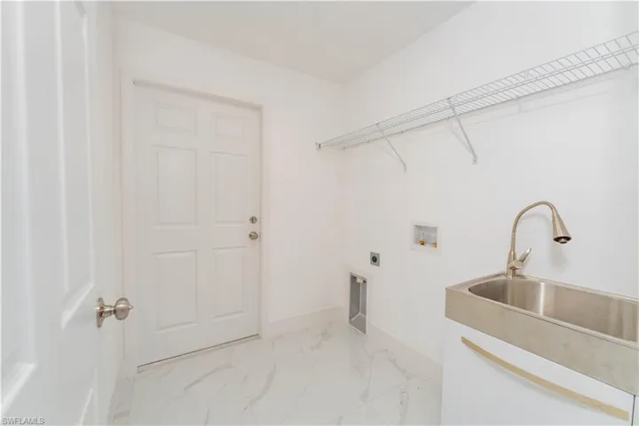 Laundry room featuring light marble finish floors, hookup for an electric dryer, and hookup for a washing machine