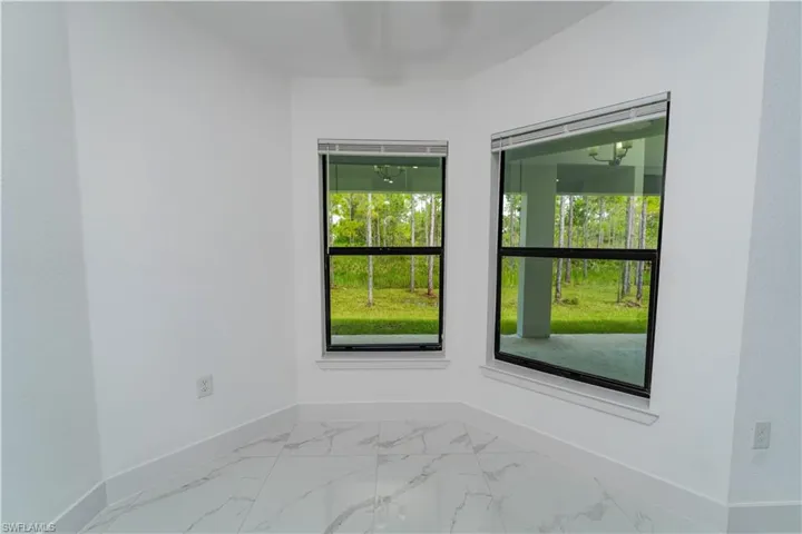 Unfurnished room with baseboards and light marble finish flooring